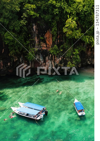 A group of tourists are snorkeling in Kilim Geopark near Langkawi Island. Boats with tourists in Kilim Park . Malaysia A group of tourists are snorkeling in Kilim Geopark near Langkawi Island. Boats with tourists in Kilim Park . Malaysia 134787311