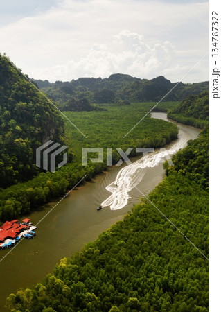 Aerial view of the fish farm in Kilim Geopark, surrounded by lush green mountains, with boats, Langkawi Island. Malaysia Aerial view of the fish farm in Kilim Geopark, surrounded by lush green mountains, with boats, Langkawi Island. Malaysia 134787322