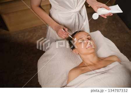 A relaxing spa treatment with skin care products for a woman who enjoys facials in a relaxed environment 134787332