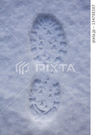 Single boot print in fresh snow with star tread pattern 134788107