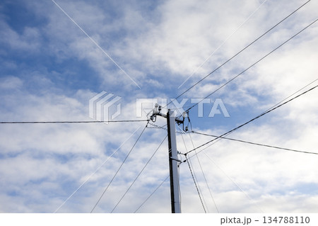 Utility pole with power lines against cloudy sky in daylight Utility pole with power lines against cloudy sky in daylight 134788110