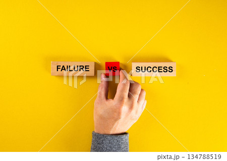 Hand choosing between failure and success on yellow background 134788519
