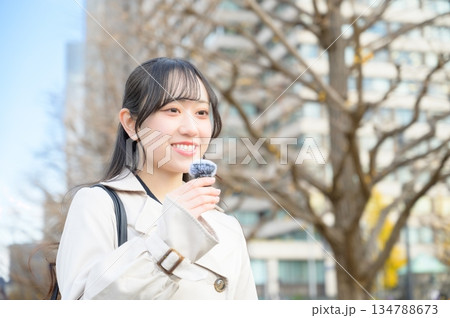 オフィス街でピンマイクを使って喋る女性 オフィス街でピンマイクを使って喋る女性 134788673