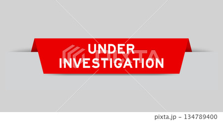 Red color inserted label with word under investigation on gray background 134789400