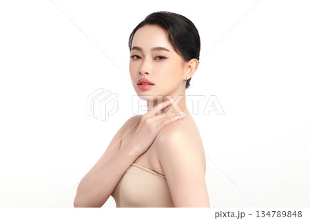 A beautiful young Asian woman with clean, fresh skin against a white background. Skincare, facial treatment, cosmetology, beauty, and spa. An elegant portrait of an Asian woman. 134789848