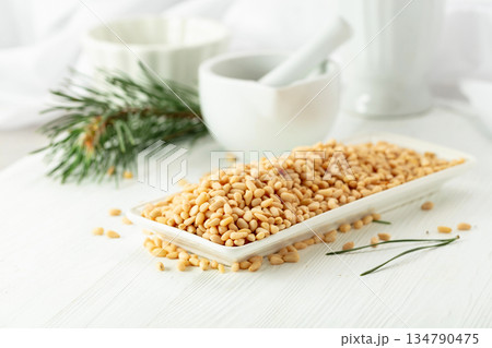 Peeled pine nuts on a white wooden table. 134790475