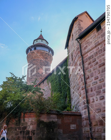 Ancient Stone Tower Rises Over Ivy Covered Wall Under Clear Blue Sky in Nuremberg, Germany Ancient Stone Tower Rises Over Ivy Covered Wall Under Clear Blue Sky in Nuremberg, Germany 134790705