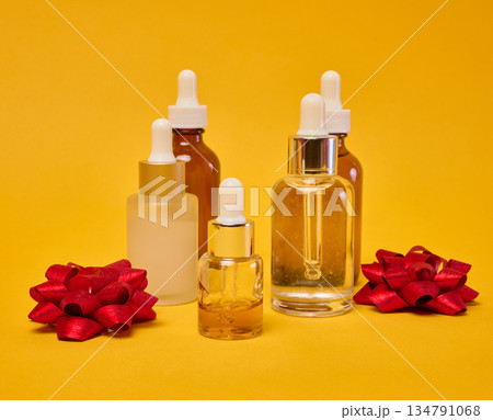 Various glass bottles with pipettes containing cosmetic serums or oils. 134791068