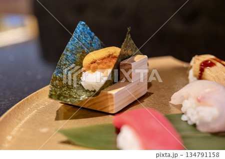 うにといくらの握り寿司・木の台座に盛られた贅沢な一品 134791158
