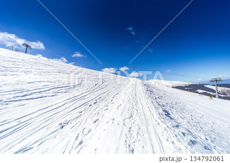 Ski Slope with Chairlift Pillars and Blue Sky in Winter Ski Slope with Chairlift Pillars and Blue Sky in Winter 134792061
