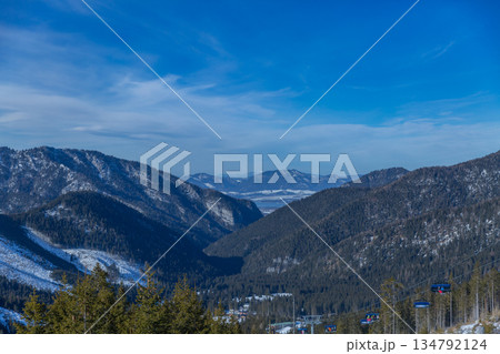 Ski Chairlift Over Forest Valley with Lake View 134792124