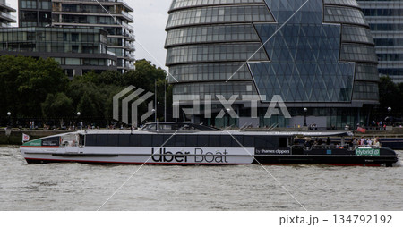 An Uber Boat Travels Along the River With Modern Buildings in Background An Uber Boat Travels Along the River With Modern Buildings in Background 134792192