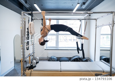 Caucasian woman doing pilates on reformer. Caucasian woman doing pilates on reformer. 134793106