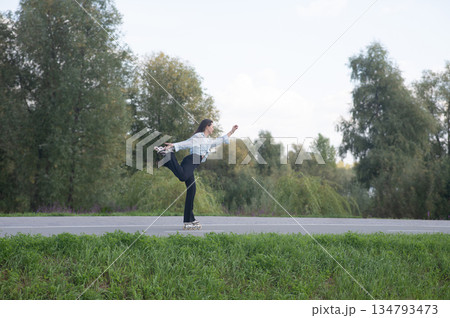 Caucasian woman roller skating in park.  134793473