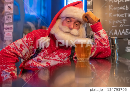 Santa Claus drinking beer at a bar. Santa Claus drinking beer at a bar. 134793796