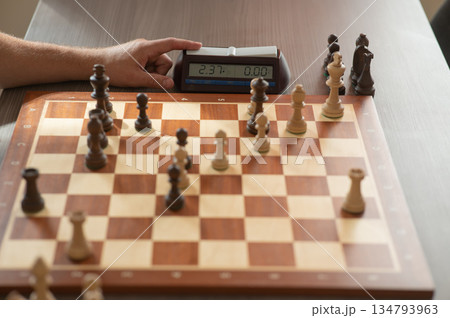 Close up of hands of middle aged caucasian man playing chess.  134793963