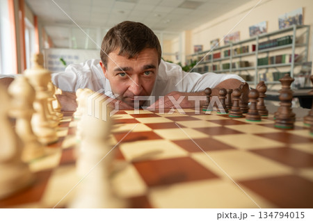 Middle aged Caucasian man playing chess. Middle aged Caucasian man playing chess. 134794015