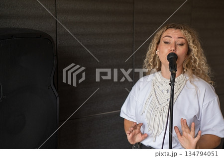 Caucasian woman singing into microphone in music studio. Caucasian woman singing into microphone in music studio. 134794051