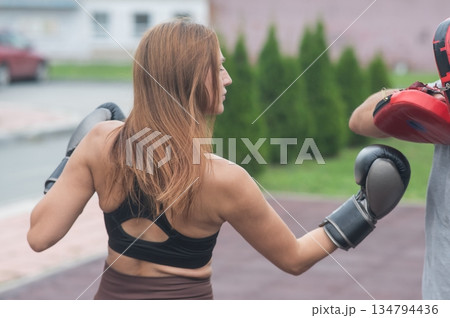 Man and woman sparring outdoors. Boxing lesson. Man and woman sparring outdoors. Boxing lesson. 134794436