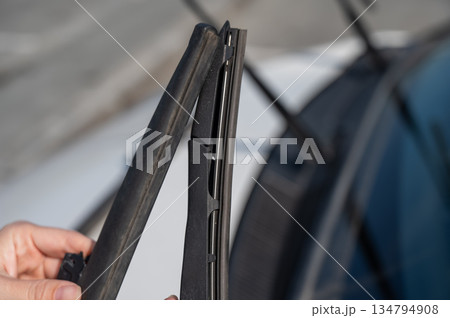 Close up of female hands changing windshield wipers. Close up of female hands changing windshield wipers. 134794908