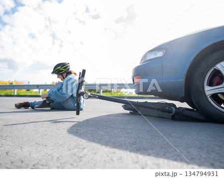 A Caucasian woman on a scooter after being hit by a car. A Caucasian woman on a scooter after being hit by a car. 134794931