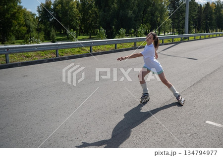 Caucasian woman rollerblading fast on road.  134794977
