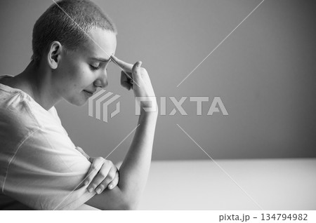 Portrait of a sad young woman sitting at a table on a white background. Copy space Portrait of a sad young woman sitting at a table on a white background. Copy space 134794982