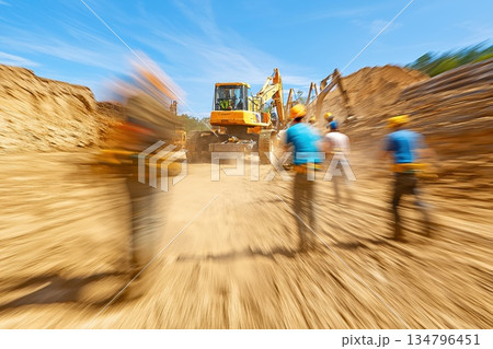 Engineers Inspecting Massive Machinery at Construction Site with Excavator Under Clear Sky 134796451