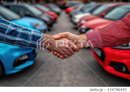 Handshake between Two Individuals at Car Dealership Amidst Colorful Cars in Background Handshake between Two Individuals at Car Dealership Amidst Colorful Cars in Background 134796493