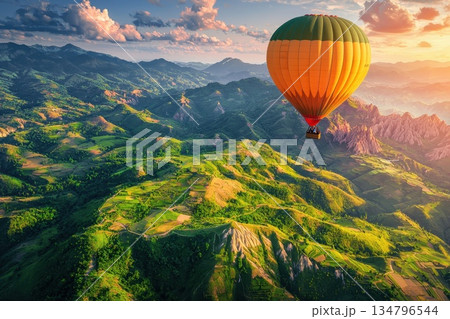 Colorful Hot Air Balloon Soaring High Above Stunning Mountain Landscape at Sunset 134796544