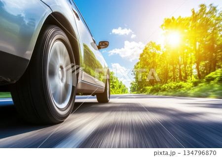 Dynamic Motion Shot of Sports Car Speeding Down a Road Under Bright Sunshine Dynamic Motion Shot of Sports Car Speeding Down a Road Under Bright Sunshine 134796870