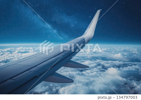 Cargo Plane Wing Under Starry Sky During Night Flight over Cloudy Horizon Cargo Plane Wing Under Starry Sky During Night Flight over Cloudy Horizon 134797003