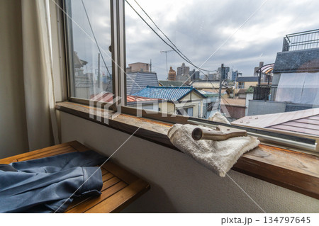 黄砂で汚れた3階の窓ガラスをスクイジーで清掃 黄砂で汚れた3階の窓ガラスをスクイジーで清掃 134797645