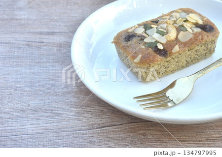 butter banana cake topping peanut and whole grain couple raisin with golden fork on plate butter banana cake topping peanut and whole grain couple raisin with golden fork on plate 134797995