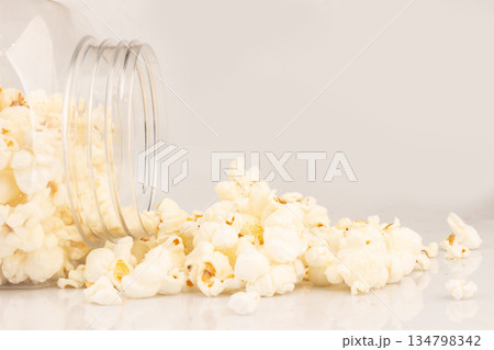 Popcorn in a clear plastic jar isolated on white background Popcorn in a clear plastic jar isolated on white background 134798342