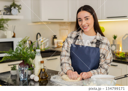 Close up young woman hands kneading dough with flour eggs milk and oil on board cooking pastry house 134799171