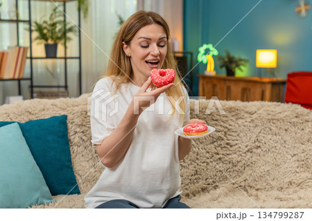 Pregnant woman bites pink donut laughs enjoys sweet treat keeps fun memory forever 134799287