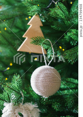 Christmas tree decoration ornaments rope ball and wooden tree shape hanging with festive lights 134799408