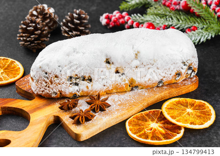 Traditional Christmas Stollen, sweet fruit loaf with sugar icing on wooden board and festive decor Traditional Christmas Stollen, sweet fruit loaf with sugar icing on wooden board and festive decor 134799413