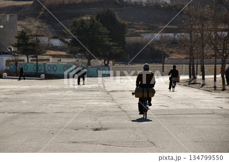 North Koreans cycling in the city of Kaesong near the DMZ 134799550