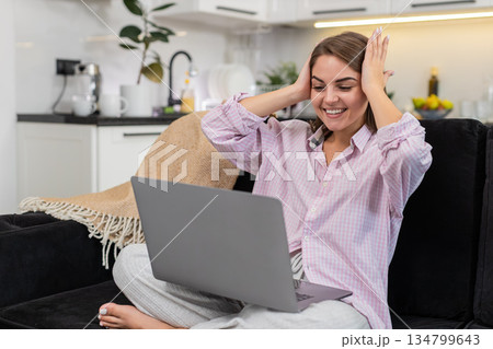 Young woman says wow lifts arms with laptop celebrates win positive news sparks joy proud reaction Young woman says wow lifts arms with laptop celebrates win positive news sparks joy proud reaction 134799643