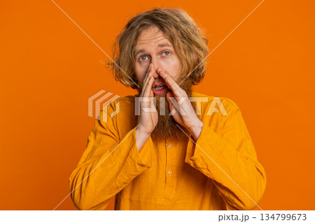 Caucasian young man whisper news rumors holding hands near mouth share gossip quiet keep my secrets 134799673