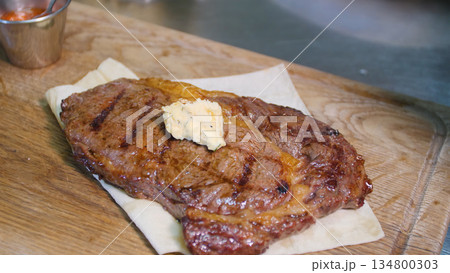 Steakhouse. Steaks are roasted on a Josper oven. The chef serves steaks on wooden boards Steakhouse. Steaks are roasted on a Josper oven. The chef serves steaks on wooden boards 134800303