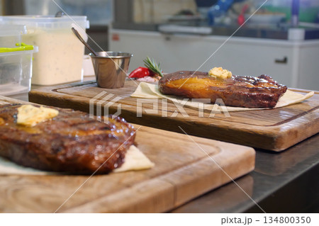 Steakhouse. Steaks are roasted on a Josper oven. The chef serves steaks on wooden boards Steakhouse. Steaks are roasted on a Josper oven. The chef serves steaks on wooden boards 134800350