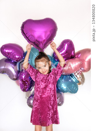 A lovely smiling beautiful girl holds a foil balloon in the shape of a heart above her, Happy Valentine's Day. The worldwide like symbol in social media and web communication A lovely smiling beautiful girl holds a foil balloon in the shape of a heart above her, Happy Valentine's Day. The worldwide like symbol in social media and web communication 134800820