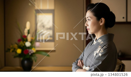 旅館の女将が生け花の先生として鋭い視線で指導する様子とコピースペース 134801526