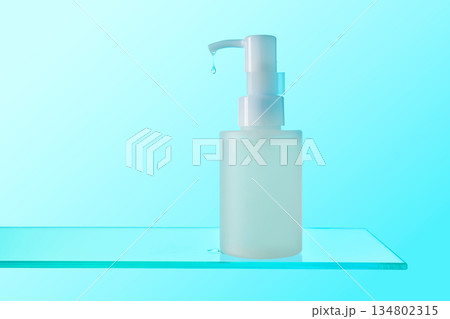 Skincare dispenser bottle dripping clear lotion on glass Skincare dispenser bottle dripping clear lotion on glass 134802315