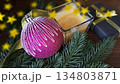The lilac ornament is near candle and pine branches 134803871