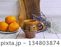 Ceramic mug and glass with oranges and lavender 134803874