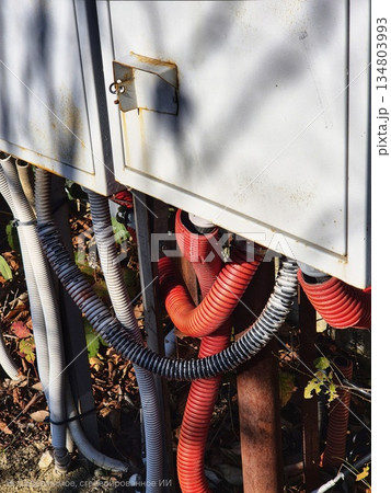 two light gray metal boxes, from under which numerous cable channels emerged in corrugations of two colors: gray and bright red. electrical panel two light gray metal boxes, from under which numerous cable channels emerged in corrugations of two colors: gray and bright red. electrical panel 134803993